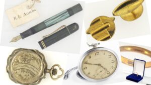 Fragment wystawy plenerowej. Od lewej znaleziony zegarek, pióro, obrączka i spinki od garnituru.