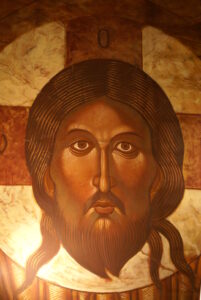 Ikona przedstawiające twarz mężczyzny w średnim wieku. Mężczyzna ma długie włosy i zarost. W tle aureola z wpisanym krzyżem.