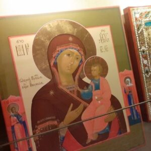Ikona przedstawiająca Matkę Boską z dzieciakiem Jezus. Ikona otoczona złotym pasem. 
