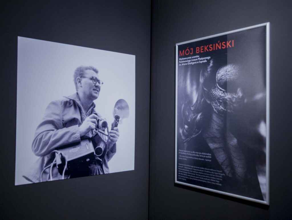 Po prawej plakat promujący wystawę, po lewej czarno-białe zdjęcie mężczyzny w średnim wieku z aparatem.